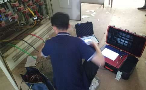 电力维护人员正在使用电缆故障测试仪对电缆故障进行查找